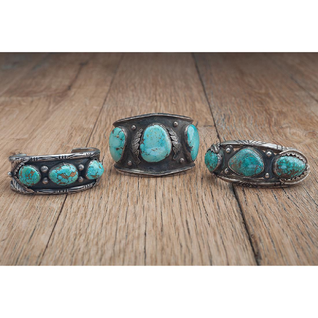 Navajo Silver and Turquoise Cuff Bracelets: lot of 3, includes a bracelet by Carl Luthy, set with three turquoise cabochons and with leaf applique, interior 7 in., gap 1.25 in.; PLUS another cuff with three turquoise stones, interior 7 in., gap