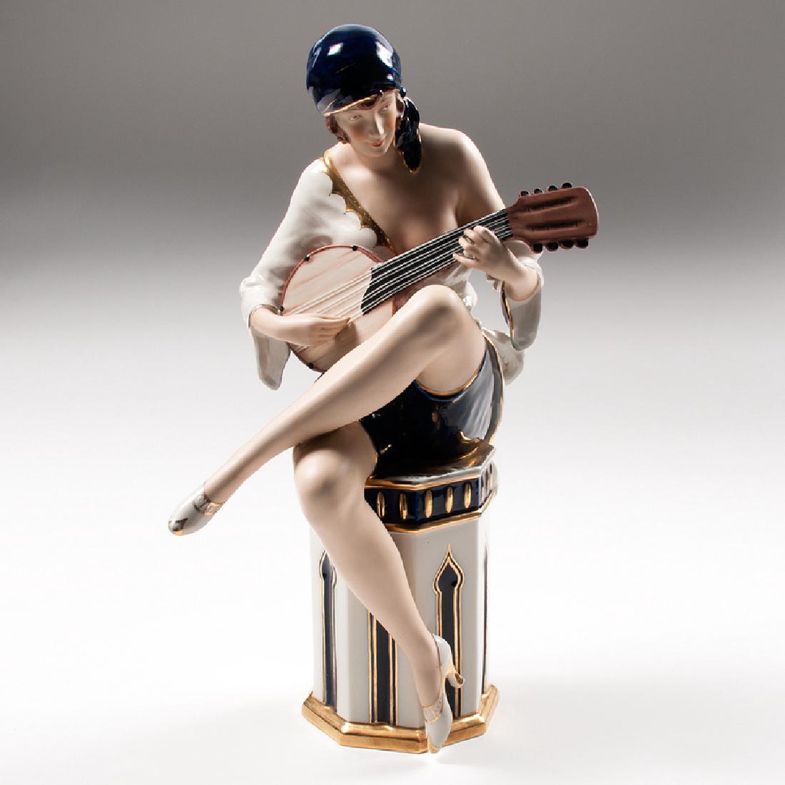 Royal Dux Woman Playing Banjo: Czechoslovakia, ca. 1920s-1930s. A porcelain figure by Royal Dux in the form of a woman playing a banjo seated on a pedestal, with manufacturer's mark and impressed 3 / 027 / 11 on underside; ht. 19.