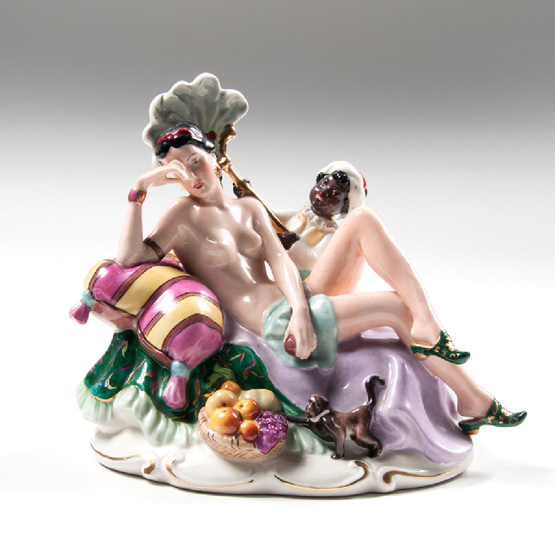 Royal Dux Exotic Woman Figural Group: Czechoslovakia, ca. 1920s-1930s. A porcelain figural group by Royal Dux depicting a semi-nude woman reclining on cushions, being fanned by a small boy and a monkey at her feet, with manufacturer's ma