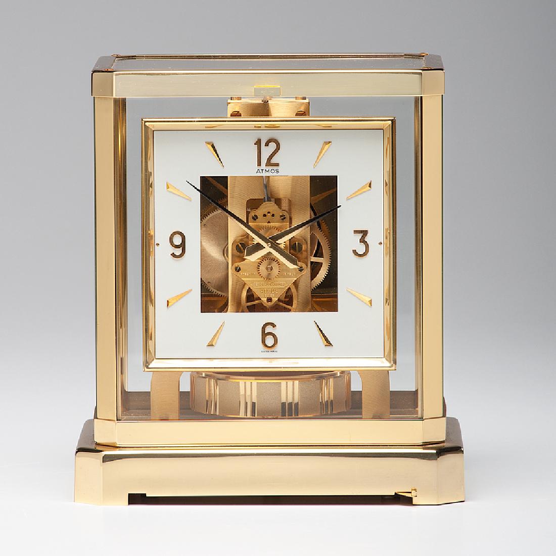 Jaeger Le Coultre Atmos Clock: Swiss, mid-20th century. A fifteen-jewel movement Atmos clock by LeCoultre, having a brass and glass case with a front door, opening to access the dial and movement release lever, serial number 52