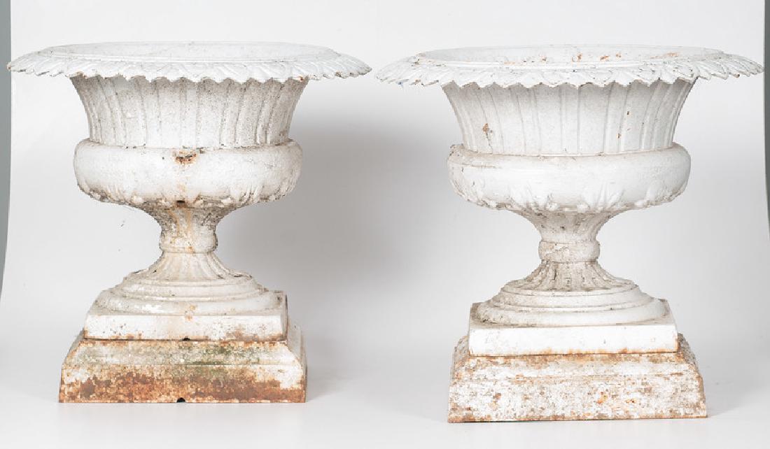 Kramer Garden Urns: American. A pair of cast iron garden urns in white paint, on square bases. Unmarked; oah. 19.5 in. (each).