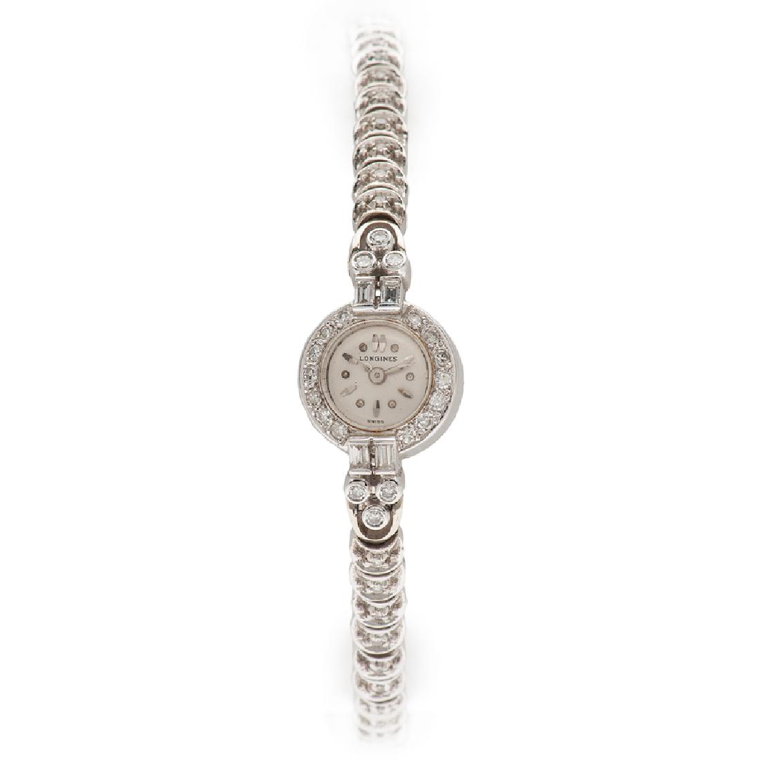 Longines Diamond Watch in 18 Karat White Gold: A Longines watch with an 18k white gold case, diamond accented bezel, Swiss movement, and diamond accented 18k white gold band. Estimated 0.75 carat total weight. Measures approximately 5.75" long. 9