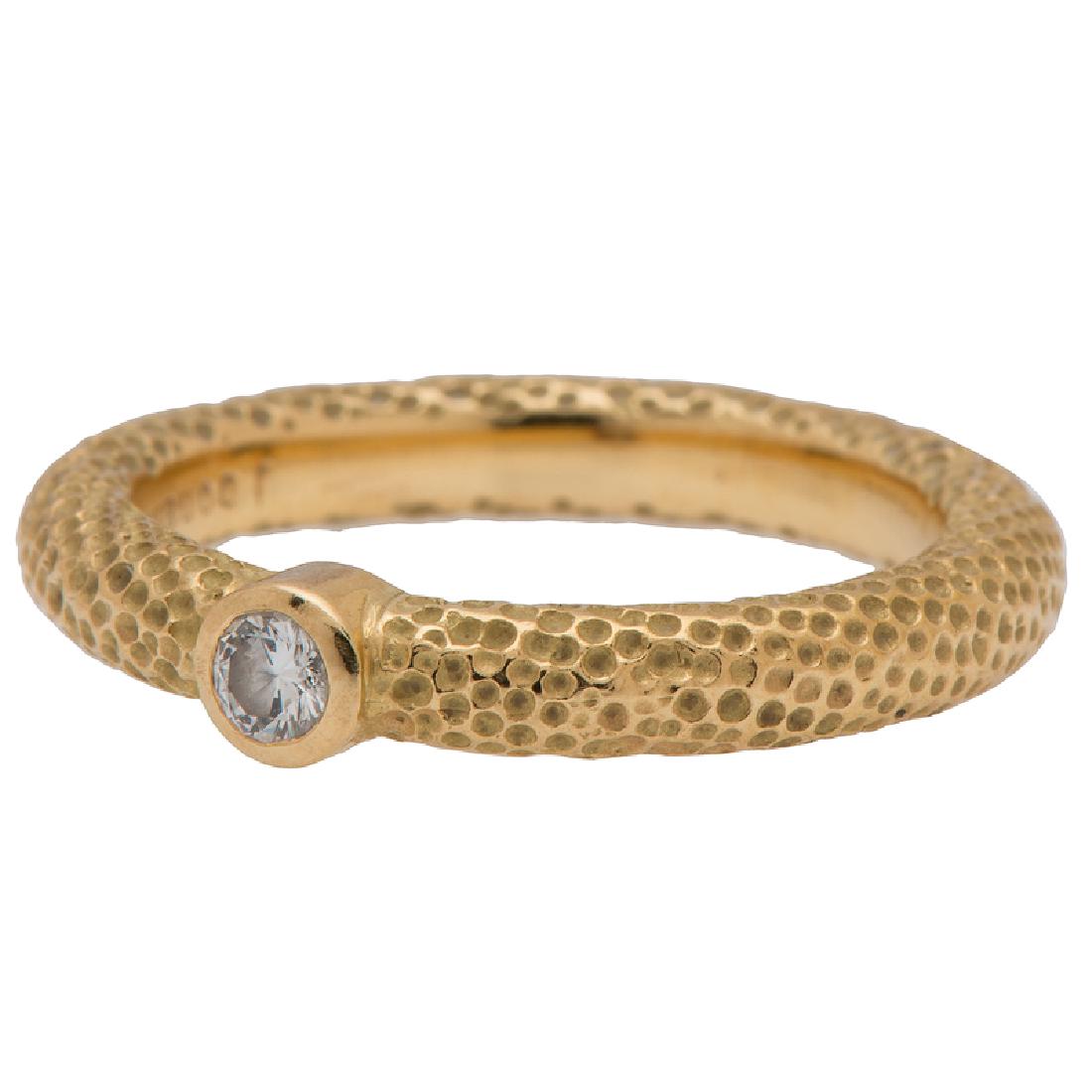 Jane Bohan Diamond Ring in 18 Karat Yellow Gold: This ring is bezel set with an 0.08 carat round brilliant cut diamond. The rounded shank features a textured dot design. Size 6. 3.7 dwt.