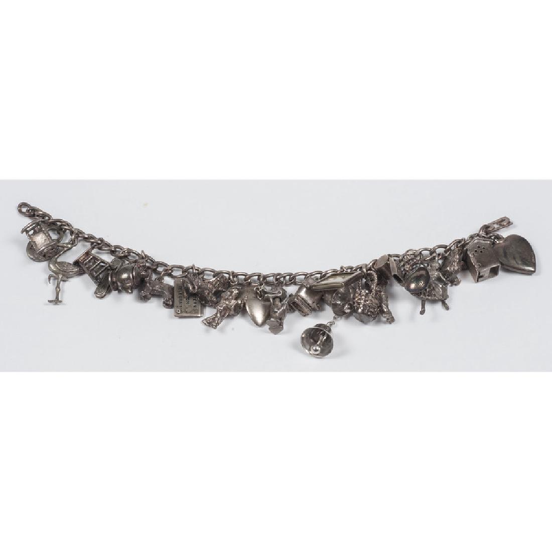 Charm Bracelet: A vintage charm bracelet. This piece is comprised of a silver tone chain with various charms, some are marked sterling. Measures approximately 6.5" long. Provenance: Property from the Collection of Dr