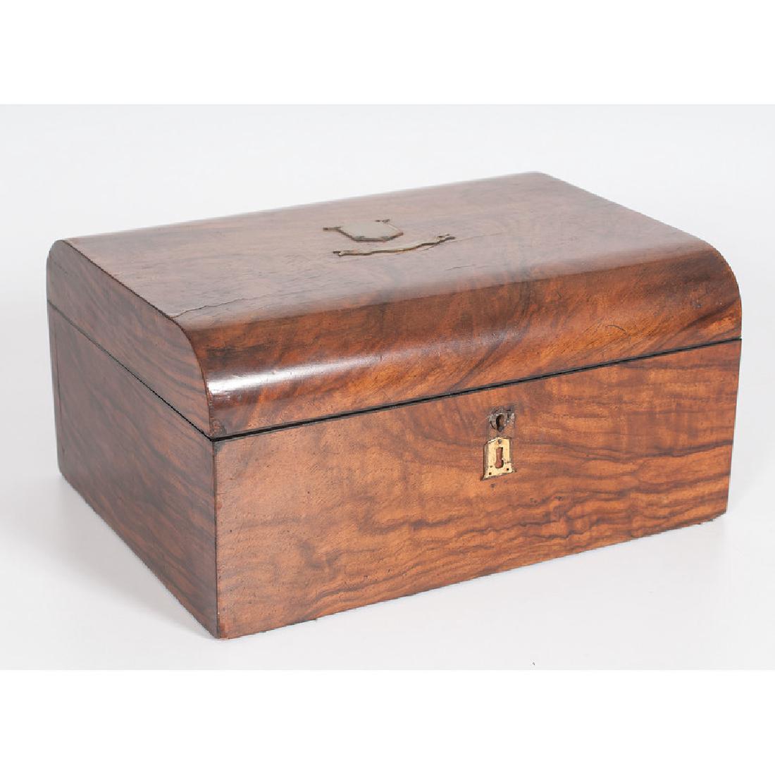 Burlwood Sewing Box: English, late 19th century. A sewing box in burlwood with slight domed lid and brass mounts, the interior lined in purple silk; ht. 5.75, wd. 11.75, dp. 8.75 in.