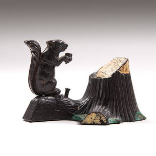 Mechanical Novelty Works Squirrel and Tree Stump: American, late 19th century. A Mechanical Novelty Works cast iron mechanical bank of a squirrel and tree stump. Place coin on top of squirrel's paws and press lever to tilt squirrel forward and deposi