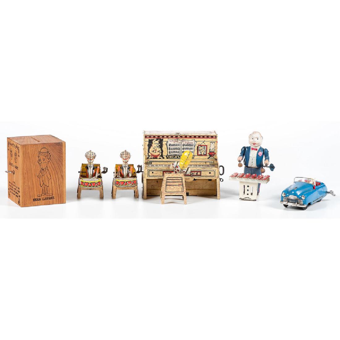 Group of Musical Toys, Including L'il Abner Band and: 20th century. A Schuco Radio 4012 with original box, a three-piece tin-lithographed L'il Abner band, a wind-up xylophone player, and a wooden Laurel & Hardy musical coin bank; Abner piano ht. 5.5