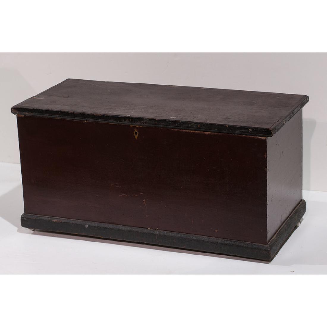 Wooden Blanket Chests: 19th century. Two blanket chests, one example in old red and black paint, on casters, and another primitive paneled chest with lift top; smaller chest ht. 18, wd. 37.5, dp. 18 in., larger chest ht. 25
