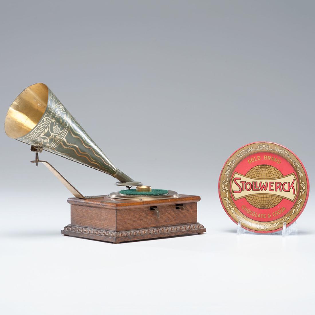 Stollwerck Chocolate Phonograph and Tip Tray: German, ca 1904. A miniature phonograph produced by Stollwerck Chocolate Company with colored tin horn and wooden case. Lot also includes a tin lithographed Stollwerck tip tray and a later magazine 