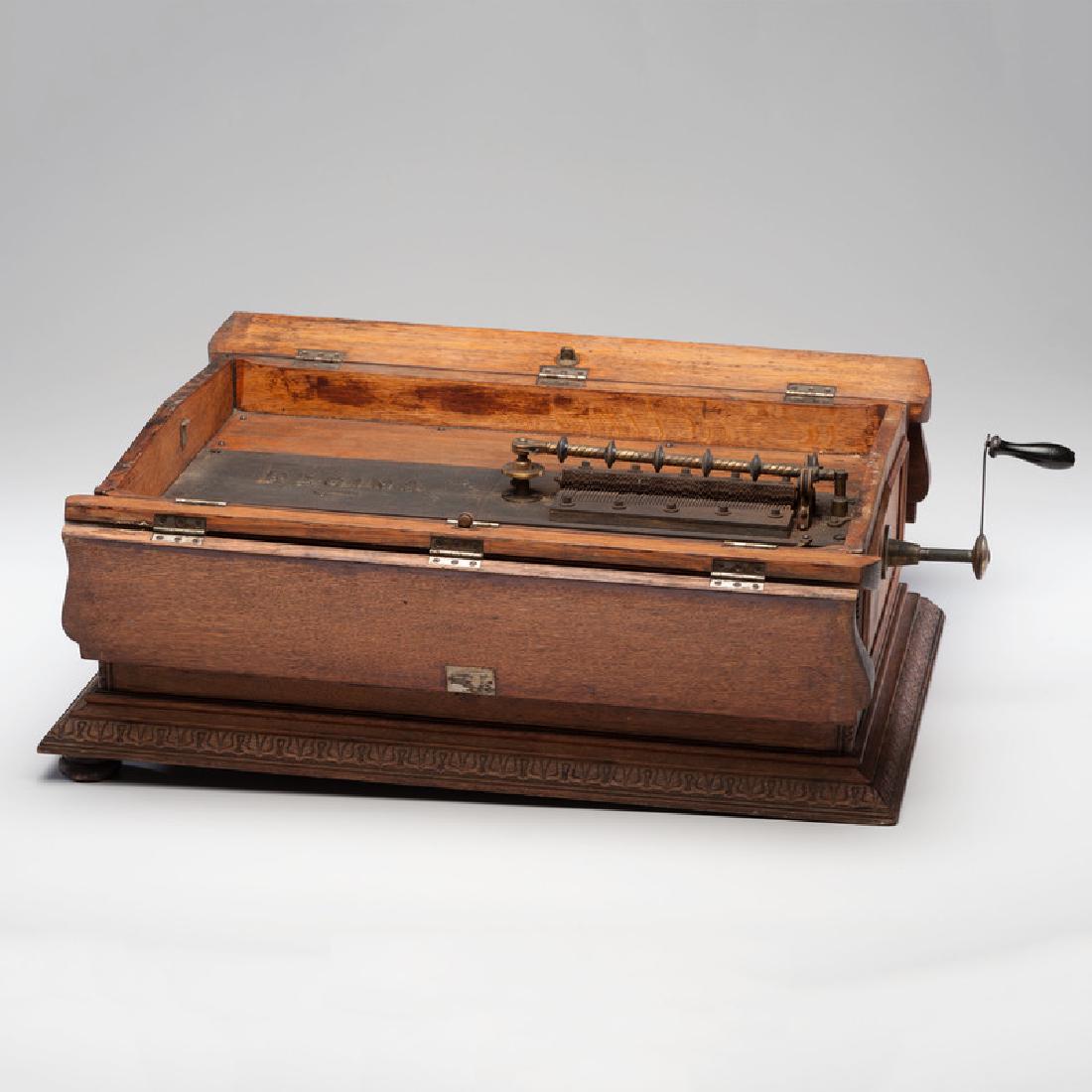 Regina Folding Coffin Top Disc Music Box: American, late 19th century. A Regina folding coffin top music box playing 20 7/8 inch discs, with a dual comb mechanism and brass bedplate, serial no. 31522. Includes crank and sixteen discs. ht