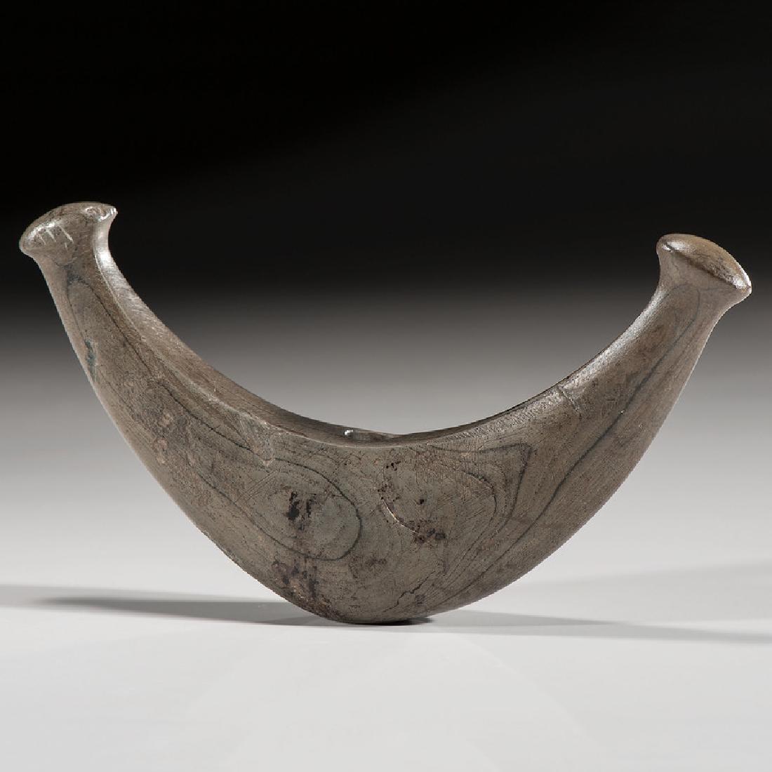 A Knobbed Crescent Bannerstone, From the Collection of: Middle Archaic Period, 8000-5000 B.C.Richland County, Ohiolength 5.625 in. The large knobbed crescent or knobbed lunate bannerstone, is one of the more highly developed of all bannerstone forms. Th