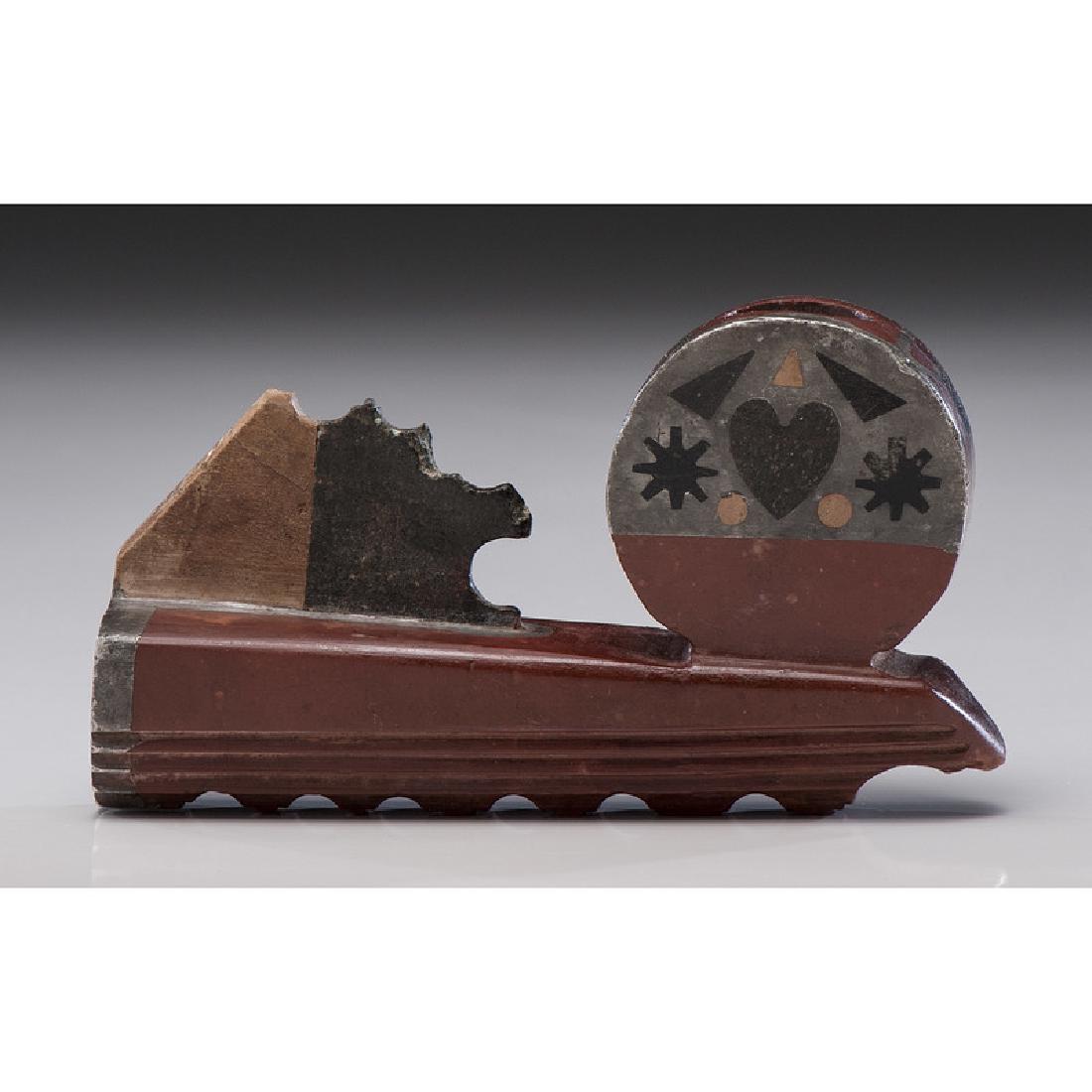 Eastern Plains Catlinite Pipe with Inlay: prominently situated on the front of the pipe is a large bulbous bowl with lead and steatite inlay; beveled lower edge with carved scalloped base; length 4.75 in. x height 2.75 in.late 19th century