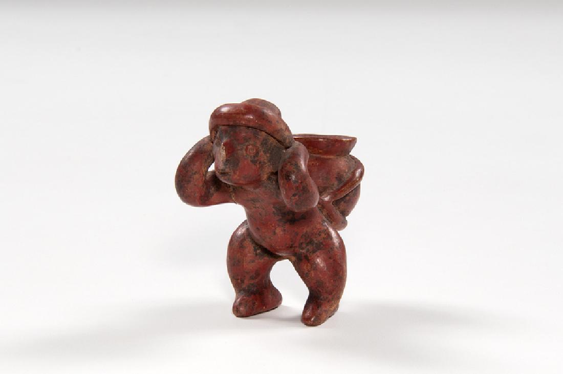 Colima Redware "Cargadora": Mexico, Colima, pre-Columbian. A redware "cargadora" (burden bearer) depicting a figure with a storage jar on his back; ht. 4, wd. 2.25, dp. 3.25 in. Provenance: Collection of Ruth Begun