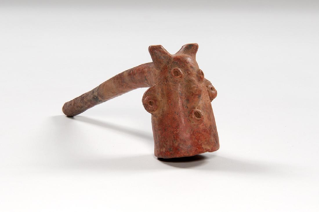 Colima Red Clay Pipe with Human Head Bowl: Mexico, Colima, pre-Columbian. A red clay pipe with a bowl in the form of a human head; ht. 3.5, lg. 8.75, dp. 2.25 in. Provenance: Collection of Ruth Begun