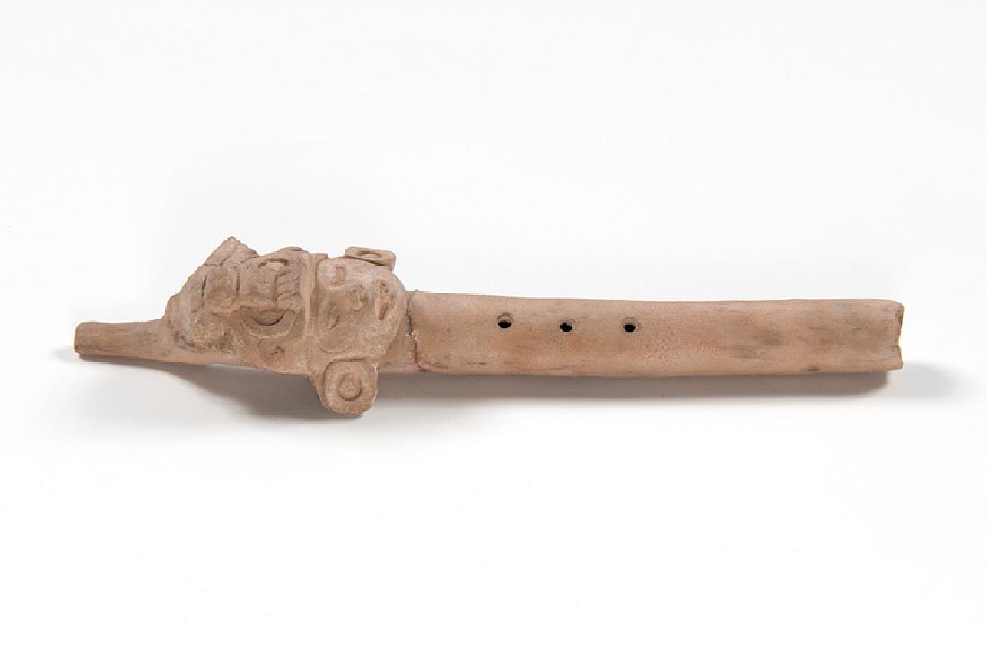 Mayan Pottery Flute: Mexico, pre-Columbian. A Mayan pottery flute adorned with a human head wearing earrings and a headdress; lg. 11, dp. 1.75 in. Provenance: Collection of Ruth Begun