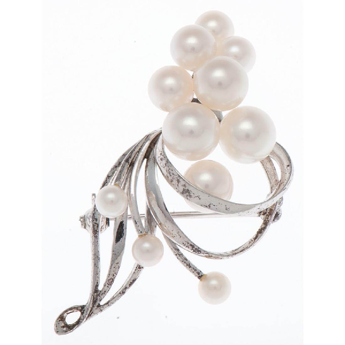 Mikimoto Sterling Silver and Pearl Brooch: Containing 11 pearls ranging from 7.5mm - 4mm. 1.875" x 1". 4.7 dwt.