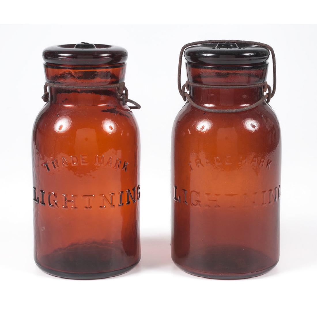 Amber Glass "Lightning" Fruit Jars: American. Two molded amber glass jars, each labeled Lightning on the side; ht. 7.75 in. (each).