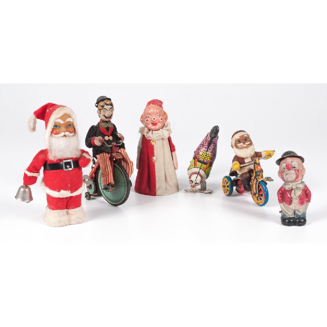 Clown and Santa Toys: 20th century. An assembled group of six toys including a mechanical Santa with a celluloid head, a plastic Santa on a mechanical tricycle, a mechanical celluloid bobblehead clown, a paper mache and fa