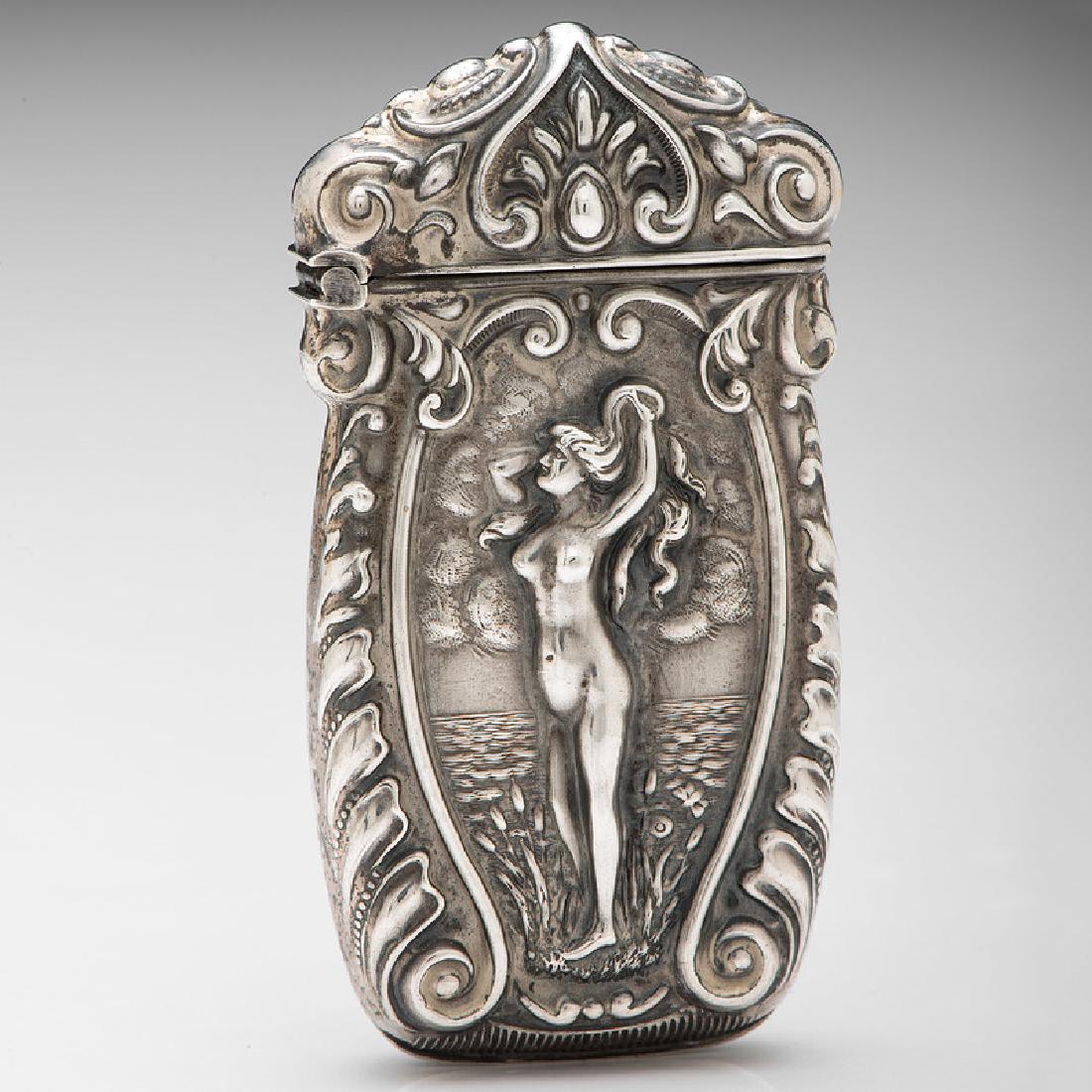 F. S. Gilbert Sterling Match Safe Featuring a Nude: American, ca 1904-1915. A sterling silver match safe by F.S. Gilbert featuring a repousse image of a nude woman by the sea, surrounded by Rococo scroll work, the verso with repousse roses, marked on 