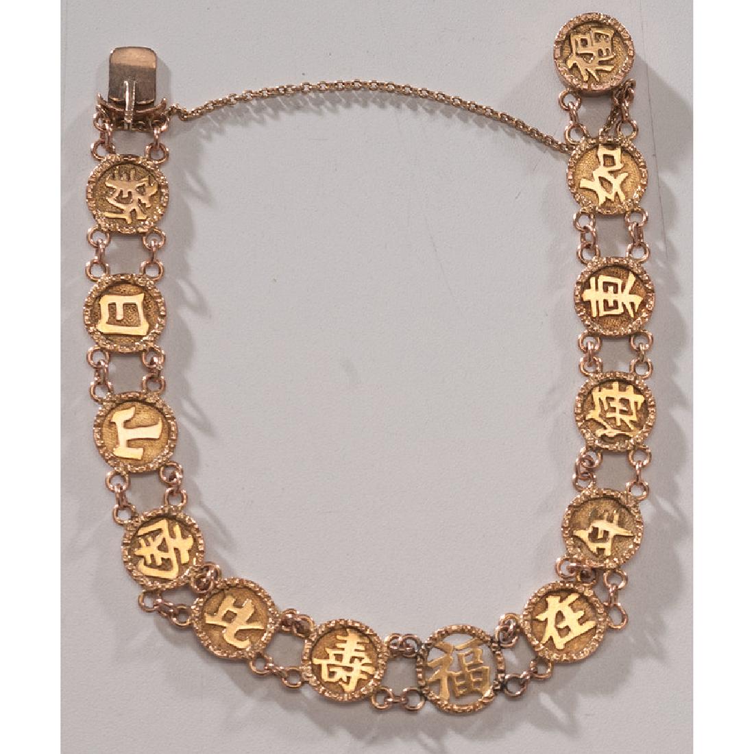 18 Karat Gold Chinese Coin Bracelet: Comprised of 18k gold coin links with tab closure and safety chain. 7.25" long. 6.6 dwt.