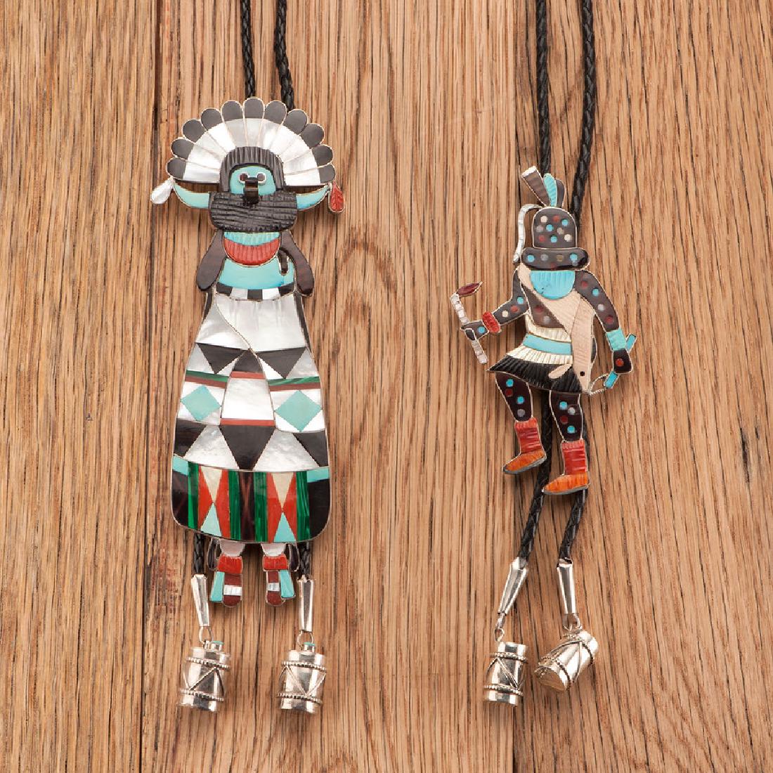Eddie Beyuka (Zuni, 1920-2002) Channel Inlay Shalako: lot of 2, includes a looming Shalako figure with shell, turquoise, coral, jet, pipe stone, and malachite channel inlay, signed on back of slide, slide height 7 in. x width 2.75 in.; AND a dancing polk