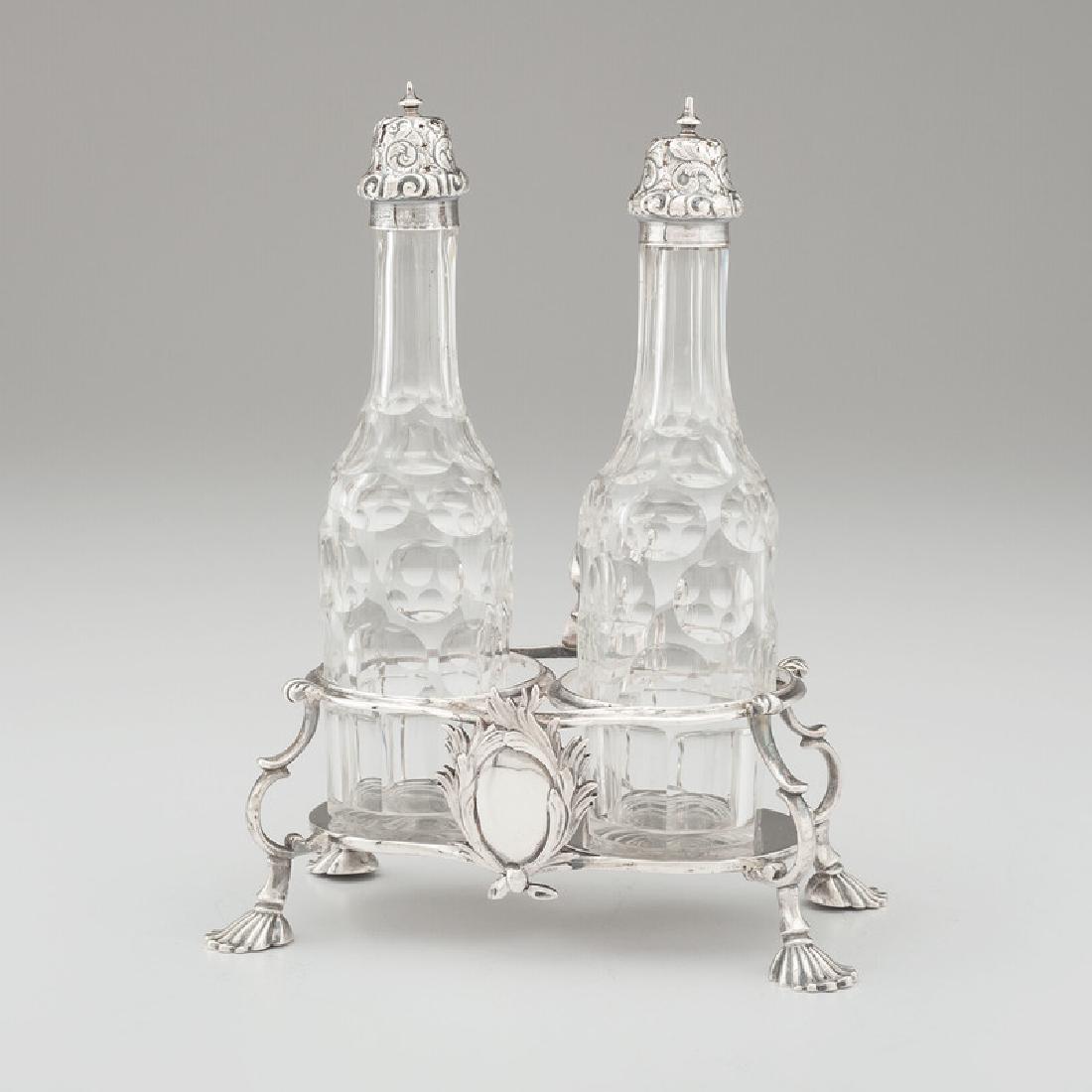 Georgian Sterling Cruet Stand: English (London), 1763. A sterling silver double cruet stand by Samuel Wood with shell feet and scroll handle, along with two later cruets with sterling lids, all with full hallmarks; stand oah. 3.75 