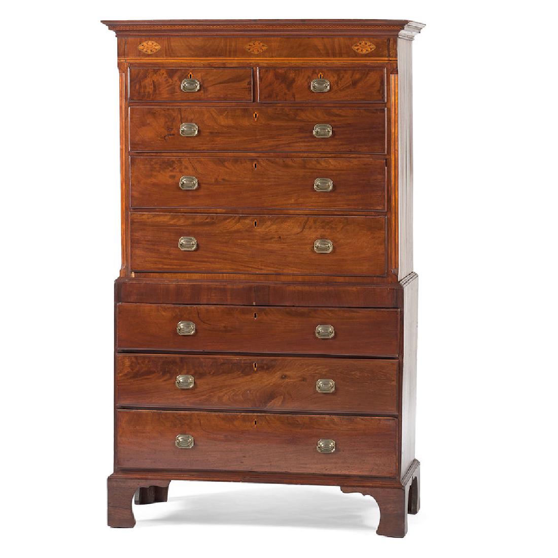 English Chippendale Chest on Chest: English, 19th century. A Chippendale chest on chest in mahogany with oak secondary, upper case having a molded, inlaid decorated cornice above a banded and floral inlaid frieze, the canted corners fla