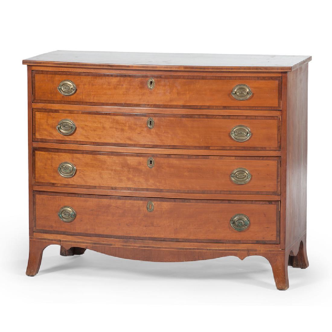 American Hepplewhite Bowfront Chest of Drawers: American, 19th century. A bowfront Hepplewhite chest of drawers in cherry, the shaped surface decorated with banding inlay, above four graduated drawers with brass pulls and mahogany veneer accents, a