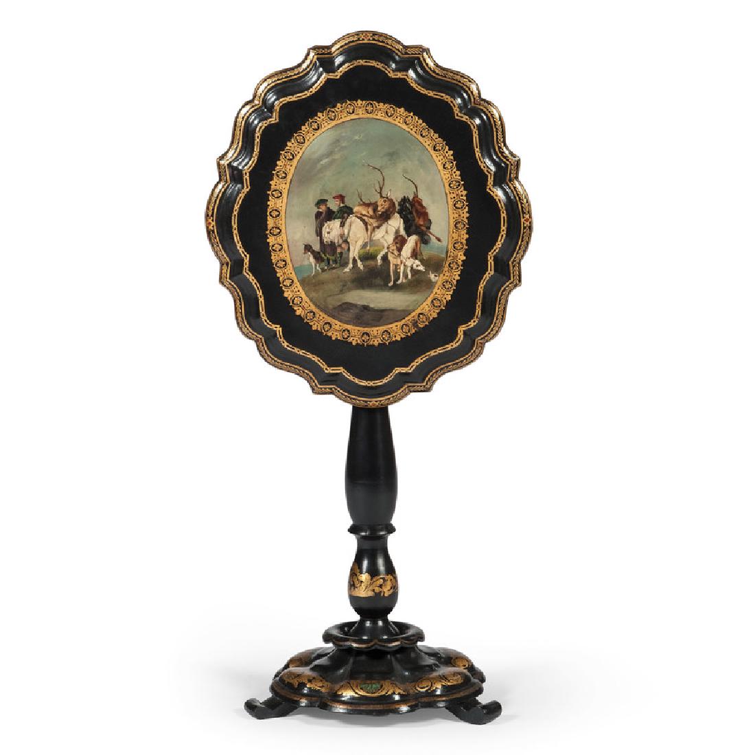 Papier-Mâché Tilt-Top Table: Continental, 19th century. A papier-mâché tilt top table in ebonized wood with gilt stenciling, having a scalloped and molded surface with central painted gaming scene, turned and decorat