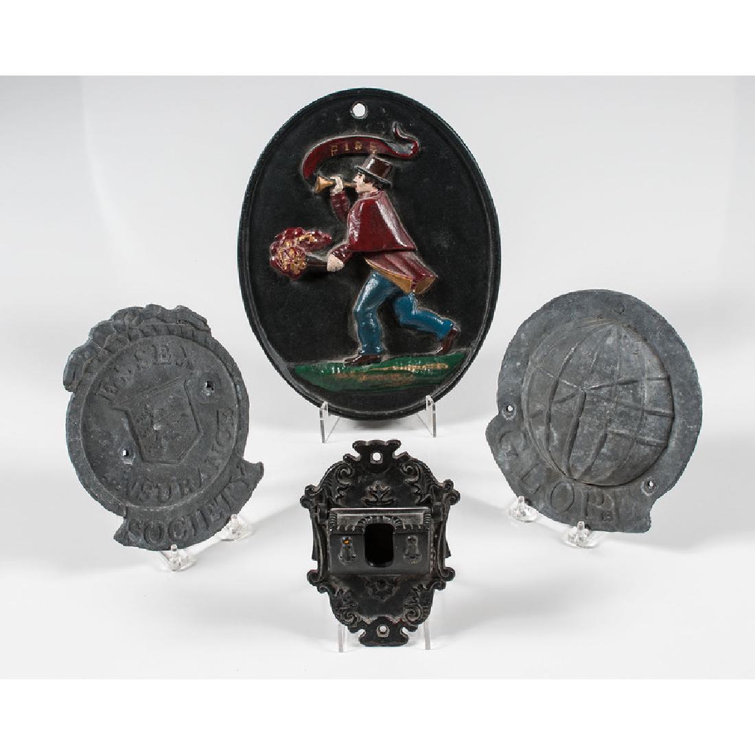 Fire Marks, Plus: 19th-20th century. Three fire marks, a painted example with a fireman, one embossed Globe and the other Essex Insurance Society, PLUS a match holder; largest lg. 11.5 in.