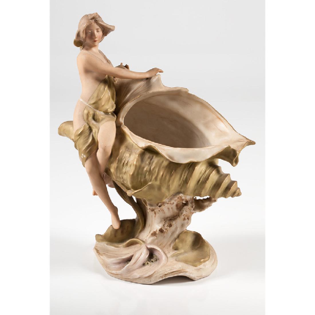 Royal Dux Art Nouveau Centerpiece: Bohemian, early 20th century. A Royal Dux centerpiece or compote in the form of a semi-nude woman seated on a shell, with pink triangle mark to bottom; ht. 15 in.