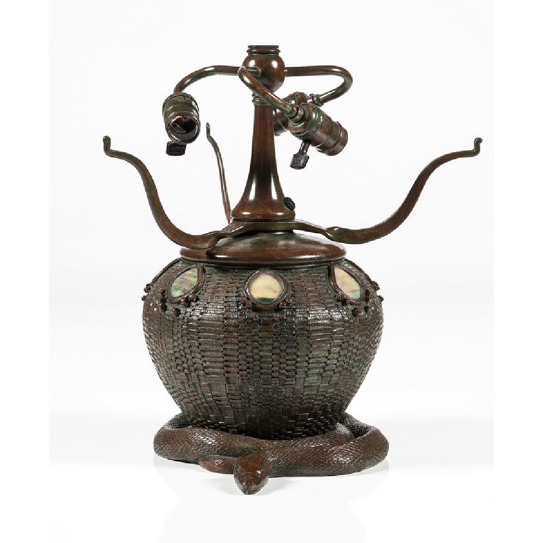 Tiffany-style Bronze Lamp Base: 20th century. A bronze table lamp base with snake and basket motif and glass inserts, with spurious Tiffany Studios mark to underside; oah. 15.5, wd. 10 in.