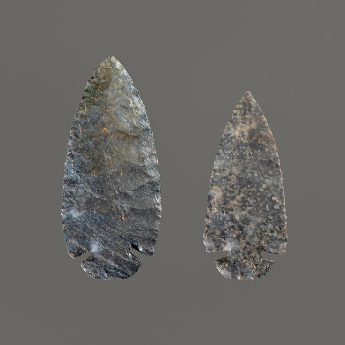 Two Coshocton Flint Dovetail Points, Longest 3-3/4 in.: Early Archaic Period, 10,000-8000 B.C. Both expertly restored on base. lot of 2, longest 3-3/4 in. Provenance: Collection History: Gerber Collection Numbers: AG.24 & AG.15 Published: Gerber, Art, The 