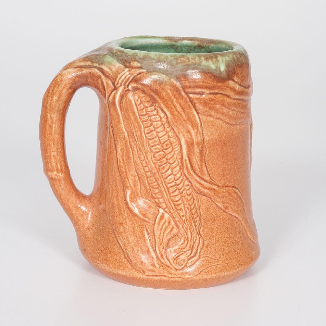 Rookwood Pottery Mug by John Wareham: American (Cincinnati, Ohio), 20th century. A matte glaze Rookwood Pottery mug executed by John Wareham, the exterior featuring a corn motif, underside marked with the Rookwood flame logo, artist's sig