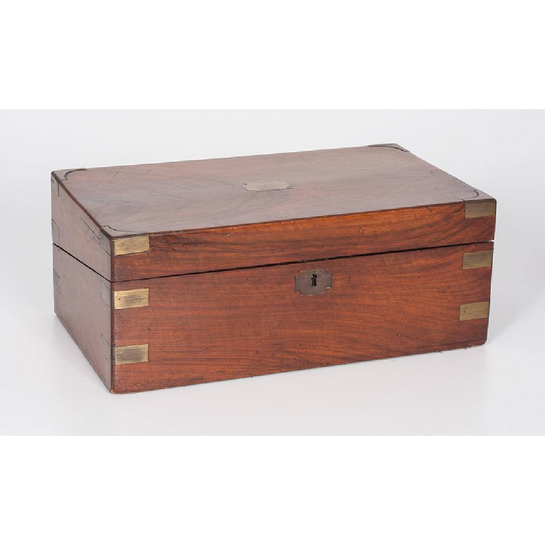 English Lap Desk: Continental, probably 19th century. A lap desk with a sloped red leather writing surface and brass mounts, with a pen tray and three small compartments, extra storage underneath writing surface; ht. 6