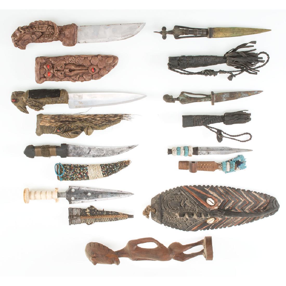 Lot of Nine African Objects: Lot includes nine objects of African origin, including a shell mounted mask, gogan knives, and several examples of beadwork knife scabbards.