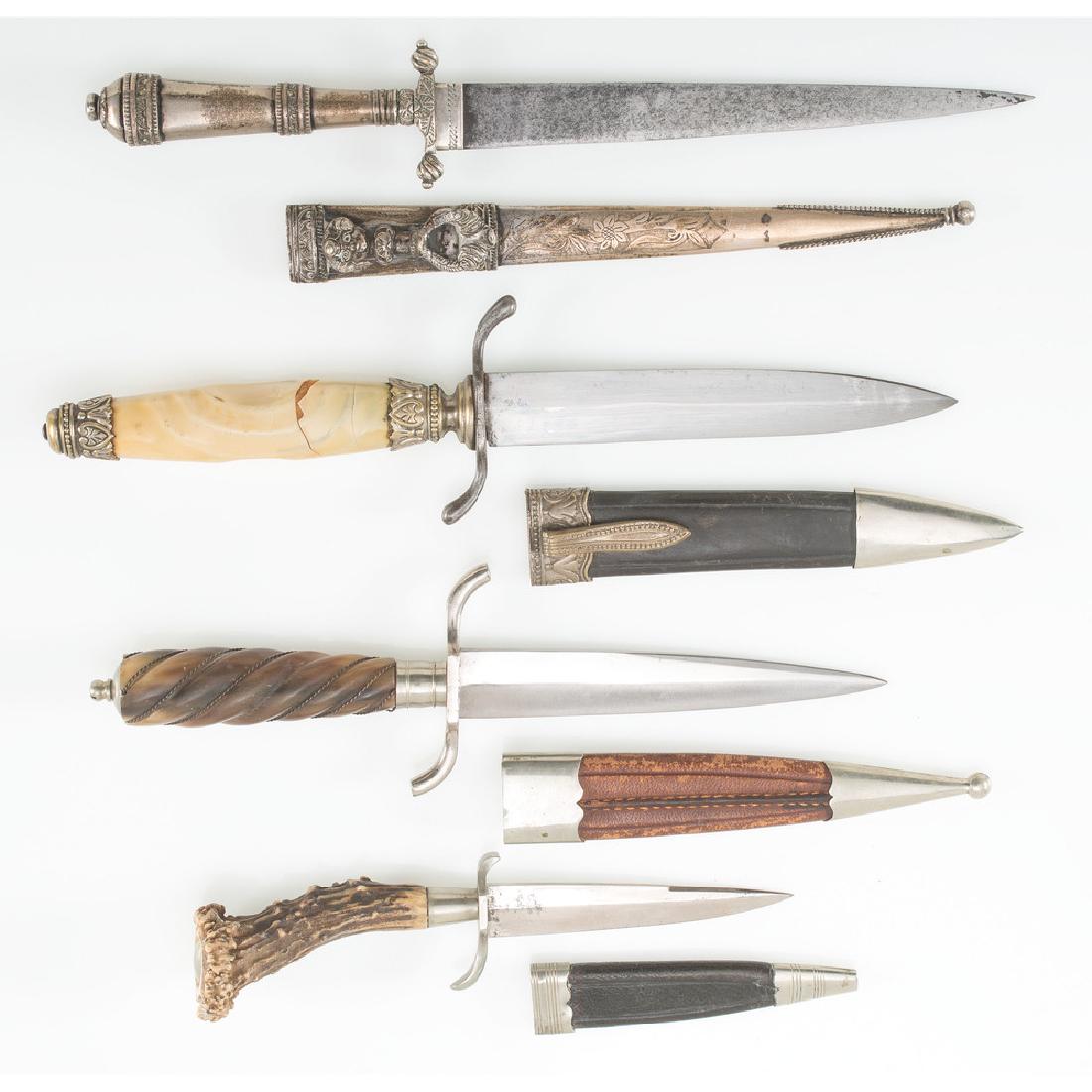 Lot of Three Daggers: 11.75 in. Silver Argentine gaucho knife with etched scabbard. Blade in good shape with Sheffield marking. 10.5 in. dagger with thermal plastic covered handle and black leather scabbard. Blade in good 