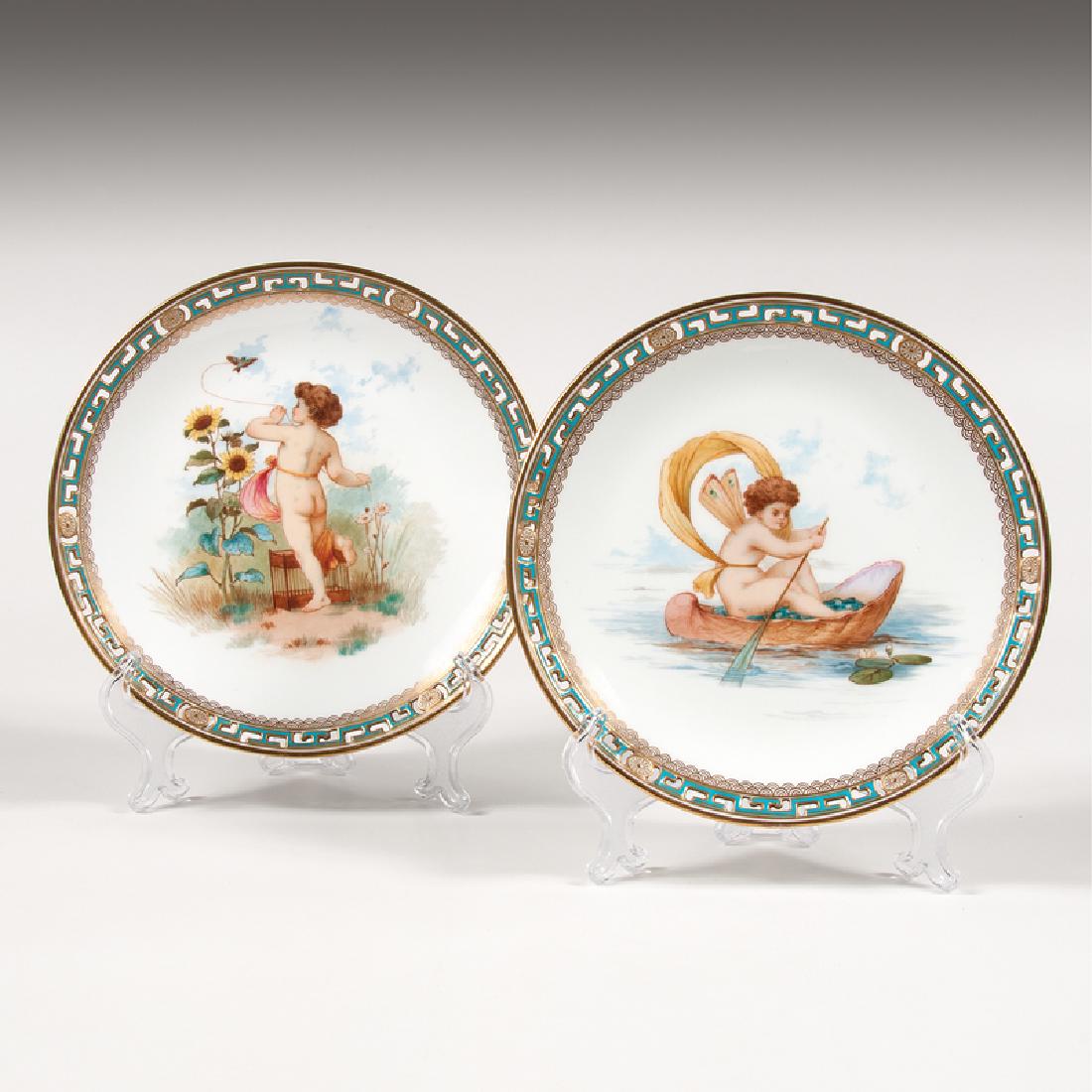 Pair Minton Cabinet Plates: English, early 20th century. A pair of two Minton cabinet plates having painted putti genre scenes in center surrounded by gilt blue pierced border, each with maker's mar
