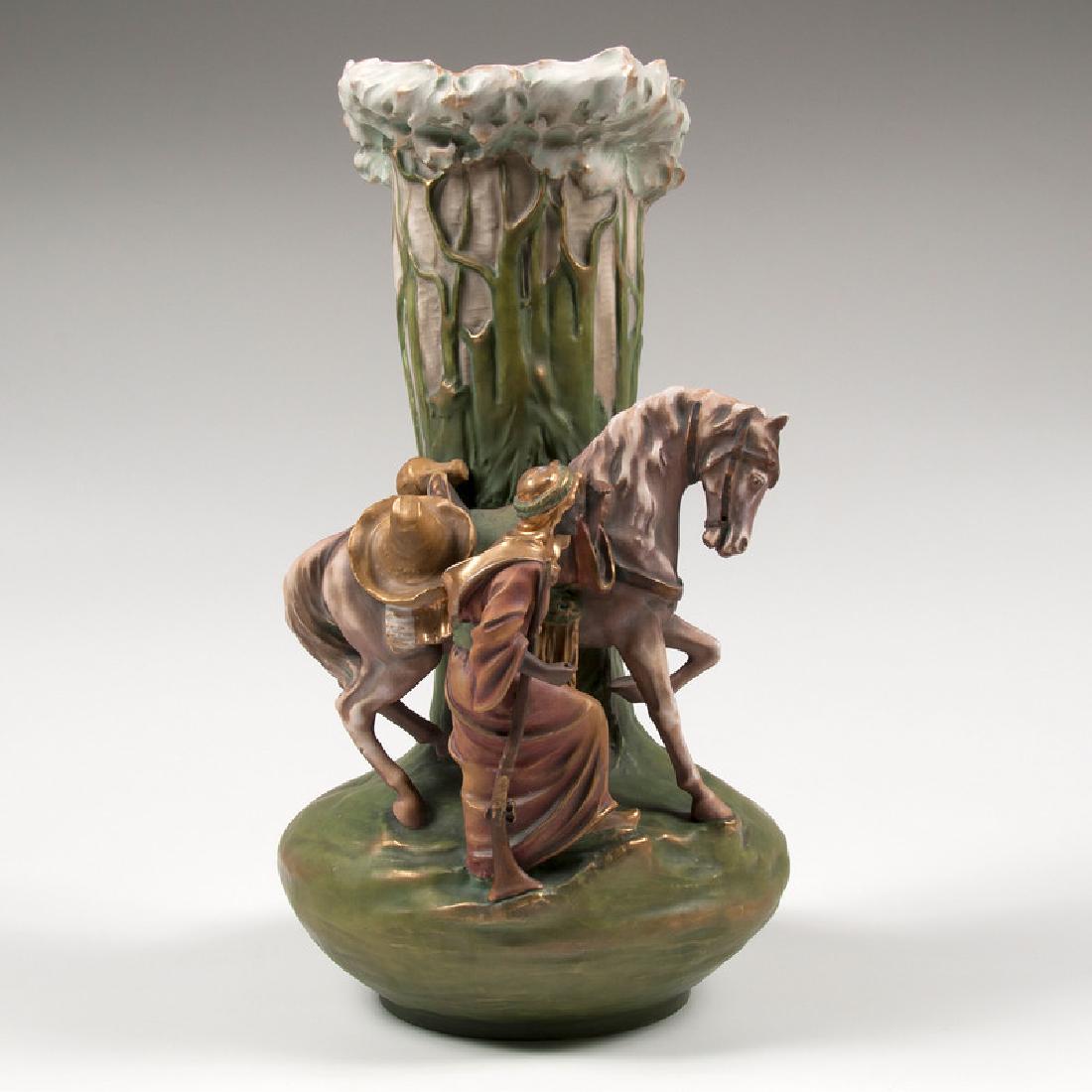 Amphora Figural Vase: Austrian, early 20th century. A Riessner, Stellmacher, and Kessel Amphora Porcelain Works bulbous-form vase, decorated with an Arabic man with gilt headdress and a horse with embossed trees, marked Im