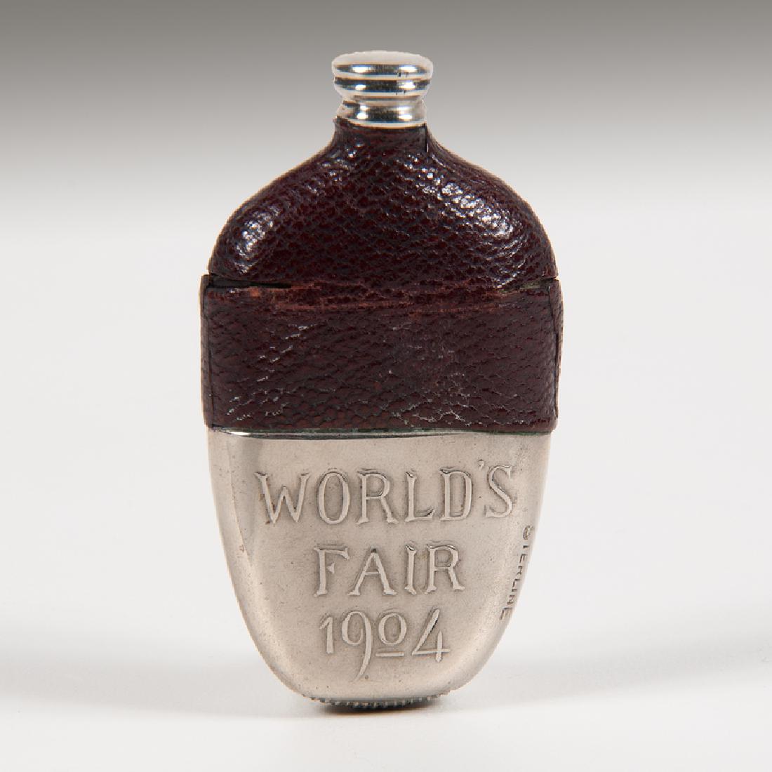 1904 St. Louis World's Fair Whiskey Flask Silverplated: American, ca. 1904. A match safe commemorating the 1904 St. Louis, MO World's fair in the shape of a whiskey flask, the top section covered in leather and the lower section silverplated, one side depi