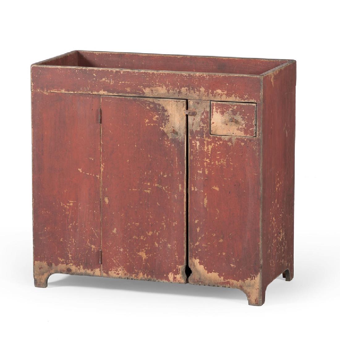 Southern Red Painted Dry Sink: American, 20th century. A reproduction dry sink in Southern pine with original red paint, with a rectangular well top, over a fitted drawer with wooden pull, the central door opening to a painted inte