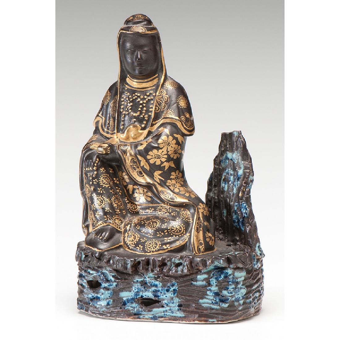 Gilt Porcelain Guanyin Figure: Chinese. A gilt and black glazed porcelain seated Guanyin figure; ht. 5.25, wd. 3.25, dp. 2 in. Provenance: 