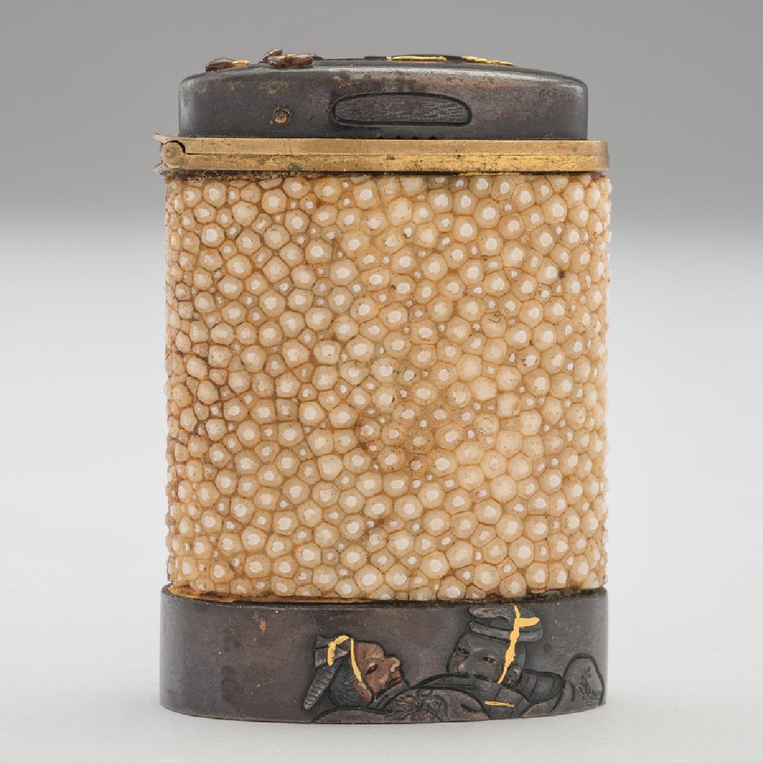 Ray Skin Match Safe: Possibly Japanese. A brass match safe with a ray skin body and gold details, decorated with flowers and Asian figures, with wooden match strike to underside, unmarked; ht. 2, wd. 1.5, dp. 0.75 in. Pro