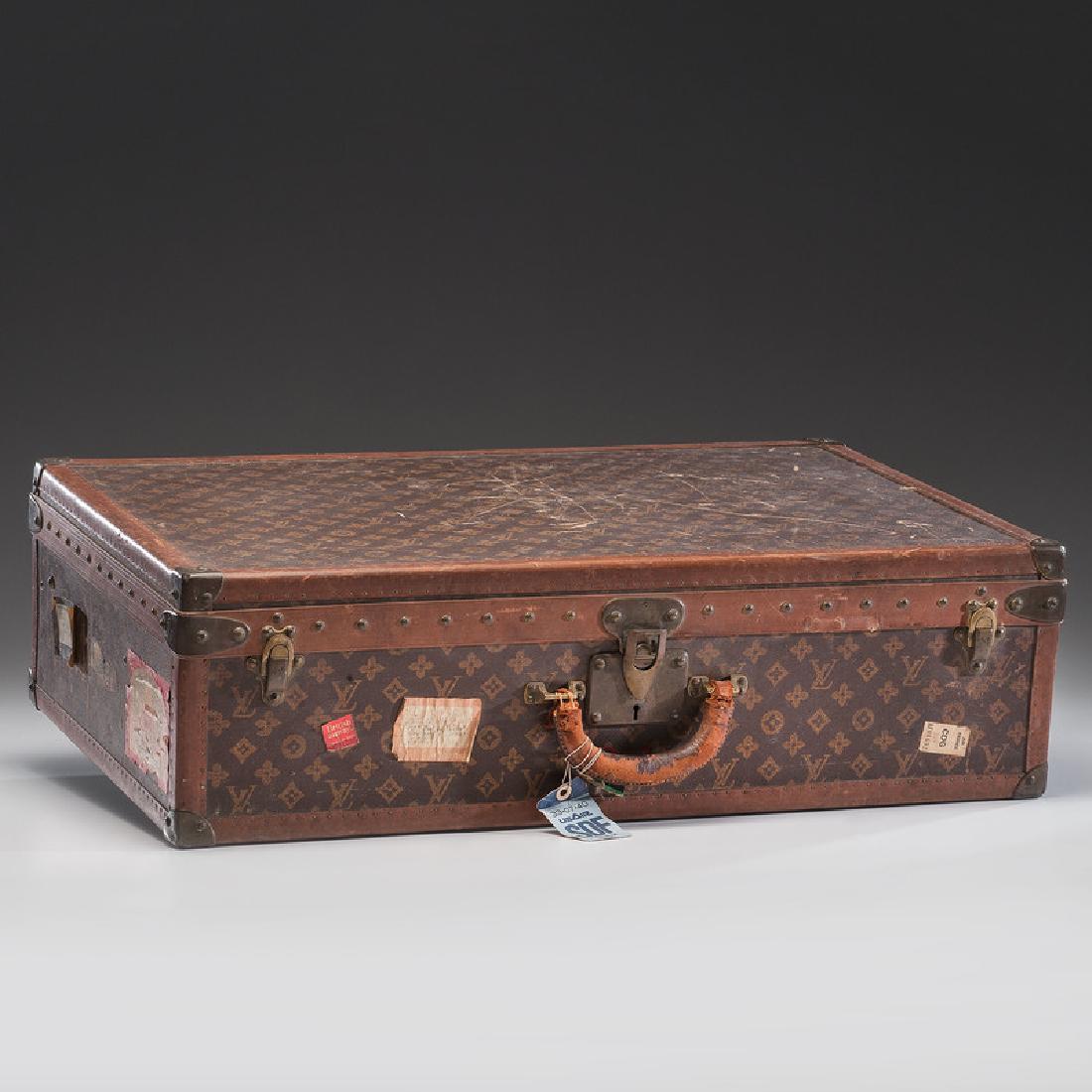 Louis Vuitton Suitcase: French, 20th century. A Louis Vuitton suitcase with a monogram canvas exterior, leather and brass-bound (all rivets and hardware are marked), opens to fitted interior with removable tray, labeled on i
