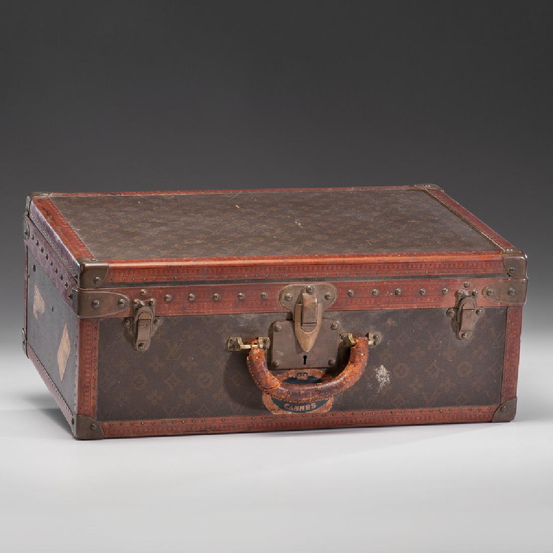 Louis Vuitton Suitcase: French, 20th century. A Louis Vuitton suitcase with a monogram canvas exterior, leather and brass-bound (all rivets and hardware are marked), opens to fitted interior with removable tray, labeled on i