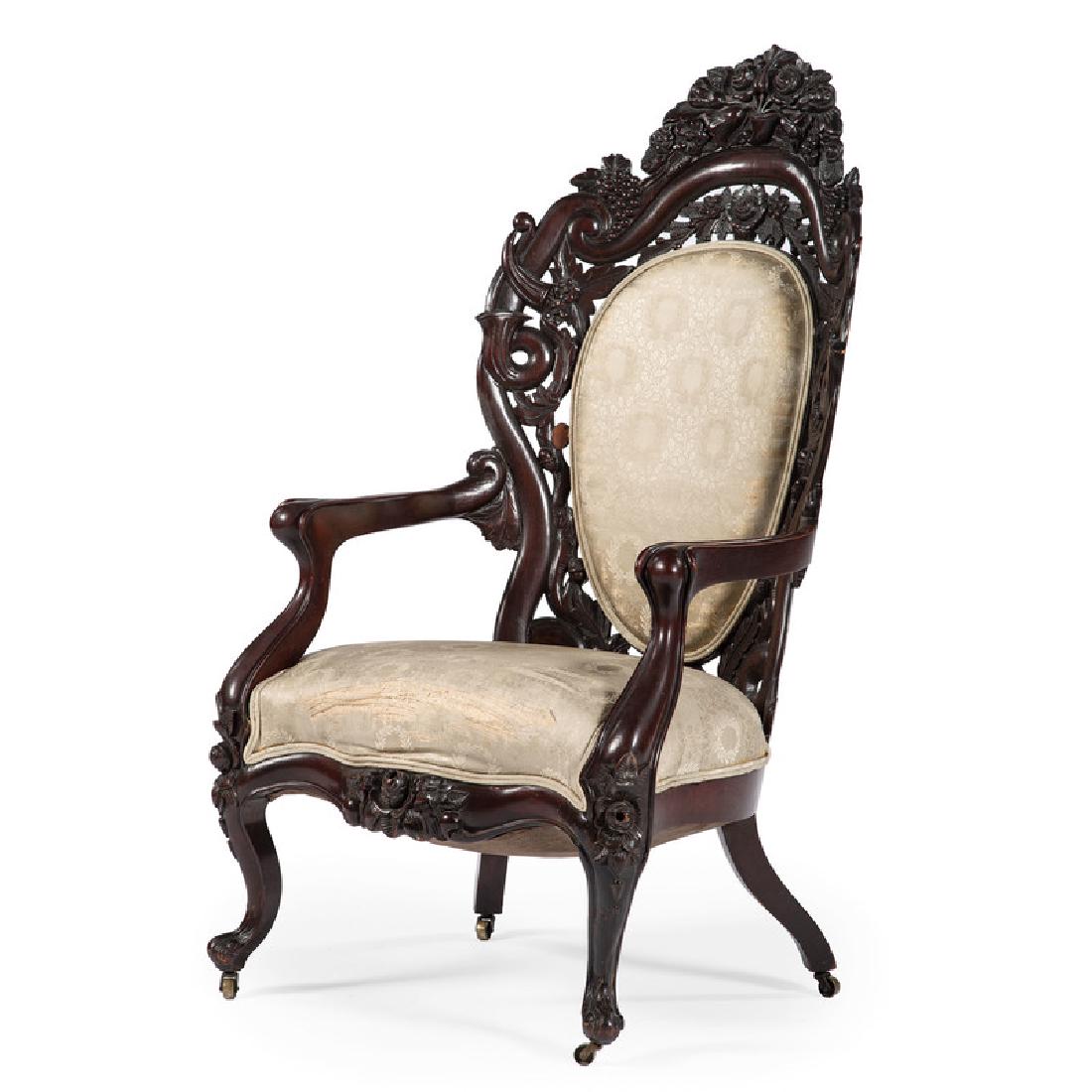 John Belter & Co. Armchair: American, 19th century. A Belter parlour armchair in rosewood, the curved laminate back pierced with serpentine scrolls, framed with floral oak leaves, roses and grapes, elaborately carved crest rail 