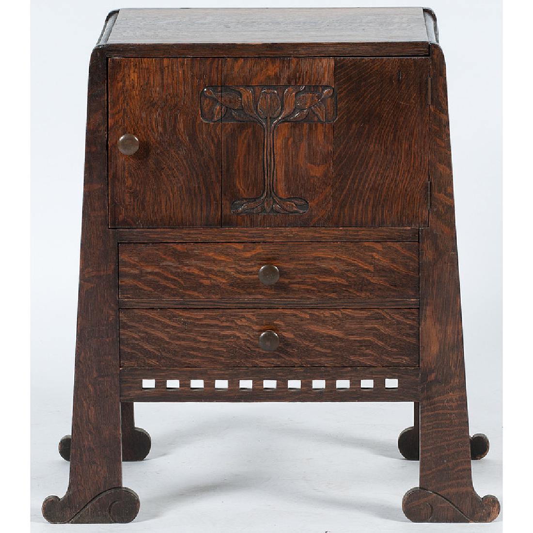 Arts and Crafts Work Cabinet Attributed to Limbert Co.: American, early 20th century. An Arts and Crafts work cabinet attributed to Limbert Co. in oak, having a rectangular surface with rounded side edge, above a single hinged door with central floral reli