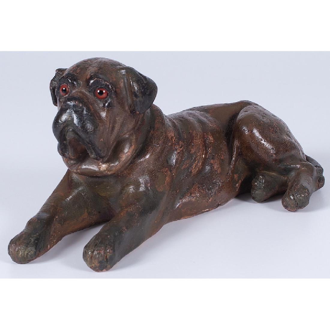 Terracotta Dog Figure: Early 20th century. A painted terracotta figure of a reclining dog with glass eyes, unmarked; ht. 5, lg. 11.25 in.