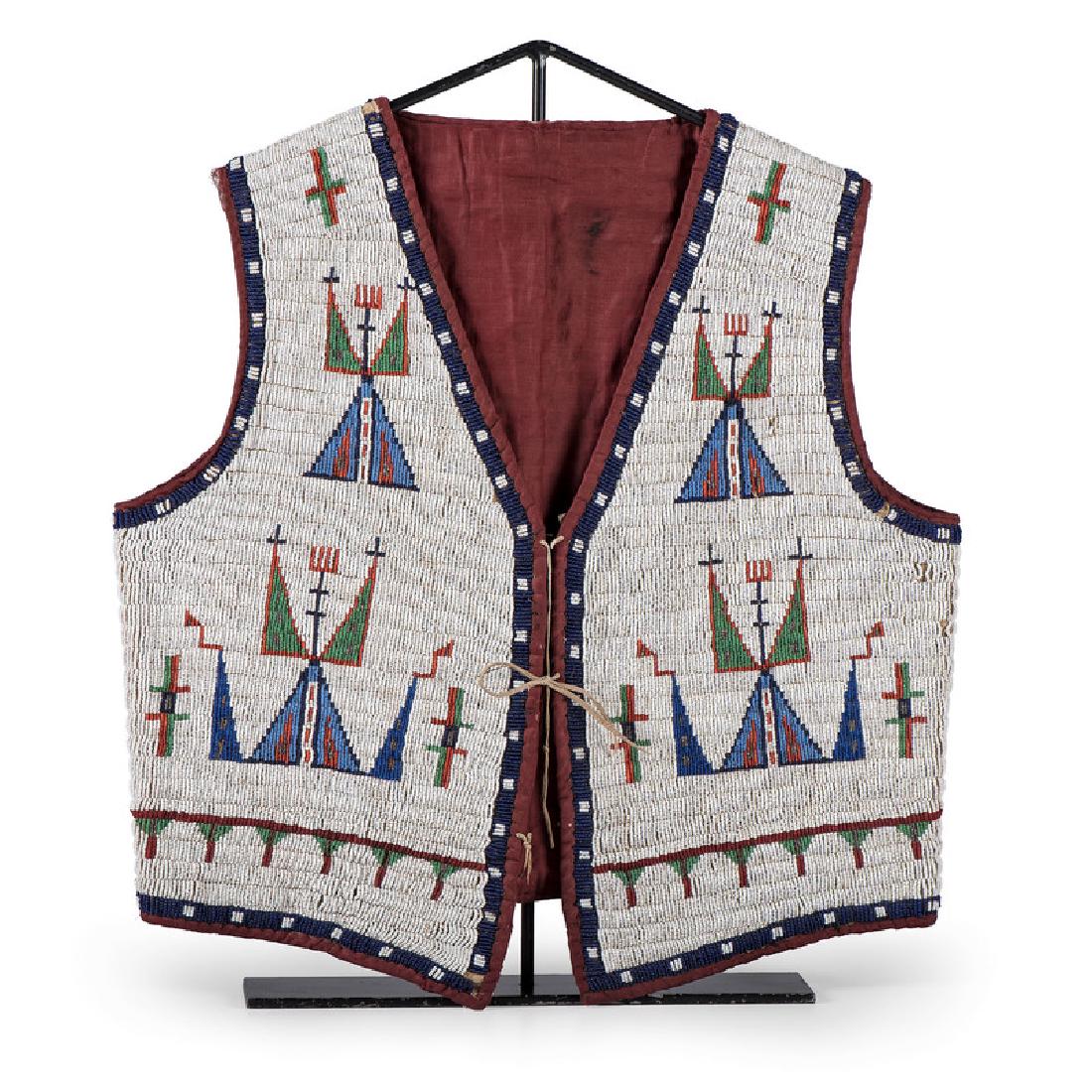 Sioux Beaded Hide Vest: thread and sinew-sewn using glass beads in colors of dark and light blue, apple red white-heart, rose, pea green, white, and faceted marcasite; interior lined with maroon polished cotton; hide thong t