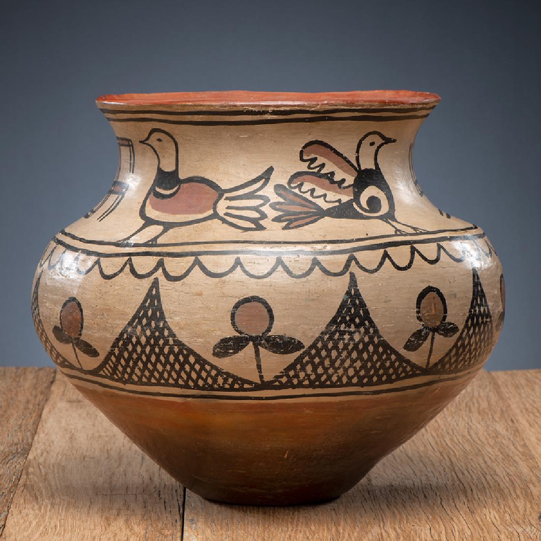 San Ildefonso Polychrome Pottery Jar: teardrop shaped body with constricted neck and flared rim; neck painted with four different birds and whirling logs; flowers and cross-hatched triangles decorate body, height 10.5 in. x diameter 12.5